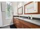 This bathroom is equipped with double sinks, wood-look cabinetry, and a wide mirror at 16179 W 70Th Pl, Arvada, CO 80007