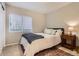 This cozy bedroom features a window view, an area rug, a comfortable bed, and a bedside table at 16179 W 70Th Pl, Arvada, CO 80007