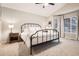 Cozy bedroom features a black metal frame bed, a ceiling fan, and a large window for natural light at 16179 W 70Th Pl, Arvada, CO 80007