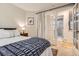 Comfortable bedroom with decorative pillows, a bedside table, and french door access to the bathroom at 16179 W 70Th Pl, Arvada, CO 80007