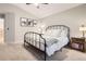 This spacious bedroom is complete with a black metal frame bed, and a nice bedside table at 16179 W 70Th Pl, Arvada, CO 80007