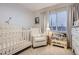 Cozy Bedroom featuring a white crib, comfortable armchair, and soft, neutral decor at 16179 W 70Th Pl, Arvada, CO 80007