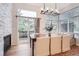 Bright dining room features a stone fireplace, a large window, and a modern chandelier at 16179 W 70Th Pl, Arvada, CO 80007