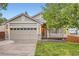 Traditional home showcasing an attached two-car garage, manicured lawn, and inviting front porch at 16179 W 70Th Pl, Arvada, CO 80007