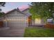 Traditional home showcasing an attached two-car garage, manicured lawn, and inviting front porch at 16179 W 70Th Pl, Arvada, CO 80007