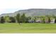 Lush green golf course with neighborhood houses in the background, with a mountain backdrop at 16179 W 70Th Pl, Arvada, CO 80007