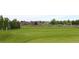 Scenic view of a golf course with its clubhouse and parking; golfers visible on the course at 16179 W 70Th Pl, Arvada, CO 80007