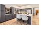 Bright kitchen features stainless steel appliances, hardwood flooring, and a quartz countertop island with seating at 16179 W 70Th Pl, Arvada, CO 80007