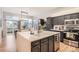 Open kitchen with an island, stainless steel appliances, modern cabinetry, and hardwood floors at 16179 W 70Th Pl, Arvada, CO 80007