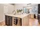 This kitchen has a large island with a sink, seating, stone backsplash, and stainless steel appliances at 16179 W 70Th Pl, Arvada, CO 80007