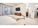 This bright main bedroom has a window, nice carpeting, a mounted television, and access to the bathroom at 16179 W 70Th Pl, Arvada, CO 80007