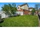 Lush green backyard featuring a white fence, patio with furniture, and well-maintained lawn at 1063 Roslyn Ct, Denver, CO 80230