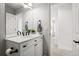 Elegant bathroom boasts a marble vanity with modern fixtures, complemented by a doorway view to the hallway at 1063 Roslyn Ct, Denver, CO 80230