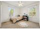 Bright bedroom features a ceiling fan and a window view, furnished with a cozy bed and bookshelf at 1063 Roslyn Ct, Denver, CO 80230