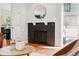 Close up of a modern fireplace with a herringbone tile surround, wooden mantel, and hardwood flooring at 1063 Roslyn Ct, Denver, CO 80230