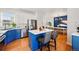 Well-lit kitchen with stainless steel appliances, two-tone cabinets, island seating, and open dining area at 1063 Roslyn Ct, Denver, CO 80230