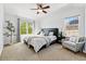 Spacious main bedroom with a comfortable bed, chair, and large windows for natural light at 1063 Roslyn Ct, Denver, CO 80230