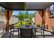 Relaxing patio with shade covering featuring table and chairs with view of well-maintained lawn at 1063 Roslyn Ct, Denver, CO 80230