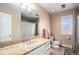 Traditional bathroom featuring granite countertops, tiled shower, and natural light from the window at 28800 E 168Th Ave, Brighton, CO 80603