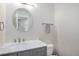 Elegant powder room featuring a marble countertop, stylish gray cabinetry, and a round mirror at 28800 E 168Th Ave, Brighton, CO 80603