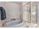 Bright bathroom features soaking tub, patterned tile and glass enclosed shower at 28800 E 168Th Ave, Brighton, CO 80603