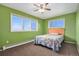 Bright bedroom with green walls, two windows, ceiling fan and a cozy quilt bed at 28800 E 168Th Ave, Brighton, CO 80603