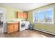 Bright laundry room with a washer and dryer, sink, and cabinets, complemented by large windows at 28800 E 168Th Ave, Brighton, CO 80603