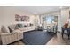 Bright living room with a beige sofa and chairs, a blue striped rug, and large windows offering scenic views at 28800 E 168Th Ave, Brighton, CO 80603