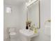 Well-lit half bathroom featuring a classic pedestal sink, toilet, gold fixtures and charming mirror at 729 E 10Th Ave, Denver, CO 80203