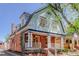 A two-story home boasting a blend of brick and light blue wood, featuring a cozy front porch with decorative pillars at 729 E 10Th Ave, Denver, CO 80203
