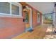 Charming front porch with a wooden door, brick exterior, and vintage-style lighting fixture at 729 E 10Th Ave, Denver, CO 80203