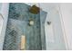 Close-up view of a luxurious shower featuring stylish tile, gold fixtures, and glass door at 729 E 10Th Ave, Denver, CO 80203