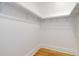 Spacious walk-in closet featuring clean white walls, wooden floors and shelving, providing ample storage at 729 E 10Th Ave, Denver, CO 80203