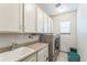 Functional laundry room with a sink, countertops, cabinets, and a modern washer and dryer at 13329 Newport Cir, Thornton, CO 80602