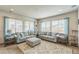 Spacious living room with two sofas, a patterned ottoman, side tables, and many windows at 13329 Newport Cir, Thornton, CO 80602