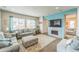 Cozy living room with a fireplace, tv, plush sofas, large patterned ottoman and cool blue accent wall at 13329 Newport Cir, Thornton, CO 80602
