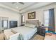 Well-lit primary bedroom with a ceiling fan, large bed, sitting bench, and coordinating nightstands at 13329 Newport Cir, Thornton, CO 80602