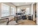 Bright home office featuring three windows, a modern desk with multiple monitors, and comfortable seating at 13329 Newport Cir, Thornton, CO 80602
