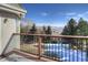 A cozy patio overlooks a spacious backyard with trees, offering a private outdoor retreat with seasonal charm at 8 Mountain Willow Dr, Littleton, CO 80127