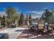 Outdoor deck featuring comfortable seating, a dining table with chairs, and scenic views of the surrounding trees and sky at 8 Mountain Willow Dr, Littleton, CO 80127