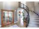 Grand entry foyer with hardwood floors, a curved staircase, and views into the living spaces at 8 Mountain Willow Dr, Littleton, CO 80127