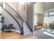 Inviting foyer featuring a curved staircase with iron railings, hardwood floors, and stylish decor at 8 Mountain Willow Dr, Littleton, CO 80127