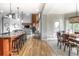 Open floor plan with kitchen island flowing into the living room with a fireplace and dining area with large windows at 8 Mountain Willow Dr, Littleton, CO 80127