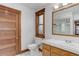 Well-lit bathroom with tile floors, wood door and window trim, and a sink with cabinets at 515 S Grant St, Denver, CO 80209