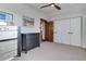 Bright bedroom featuring neutral carpet, ceiling fan, closet, and dark-toned dressers at 515 S Grant St, Denver, CO 80209