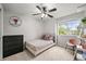 Bedroom with a ceiling fan, natural light from the window, carpeted floors, a black dresser, and a small, plush chair at 2667 E 132Nd Ave, Thornton, CO 80241