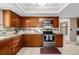 Kitchen view showcases wood cabinets, stainless steel appliances, tiled backsplash, and decorative accents at 4006 S Atchison Way, Aurora, CO 80014