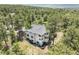 An aerial view of the backyard showing lush mature trees and a beautiful stucco home at 1240 Lone Scout Lookout, Monument, CO 80132