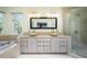 Bright bathroom with double sinks, tiled counter and floors, a jacuzzi tub, and separate glass shower at 1240 Lone Scout Lookout, Monument, CO 80132
