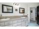 Bright bathroom featuring a double sink vanity with matching framed mirrors and neutral countertops at 1240 Lone Scout Lookout, Monument, CO 80132